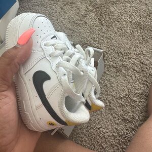 Nike White Toddler Sneakers with Black Swoosh and Yellow Heel
